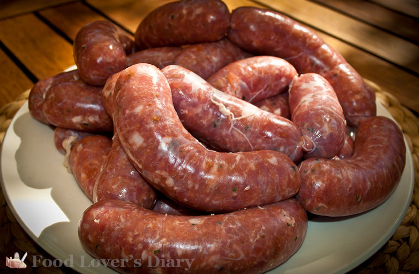 Homemade sausages on a plate on the patio table.